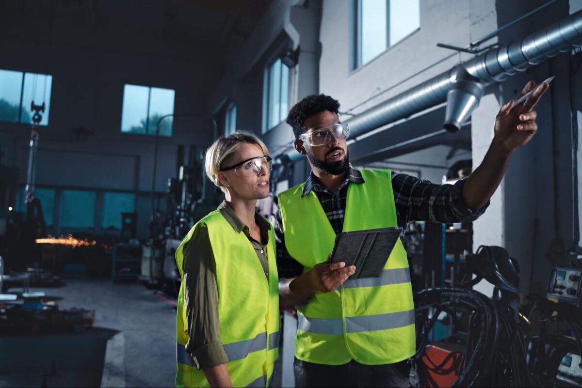 two industrial workers pointing at something