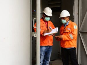 two men standing, one holding an incident reporting checklist