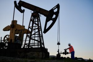 oilman-regulating-valve-on-pipeline-near-pump-jack