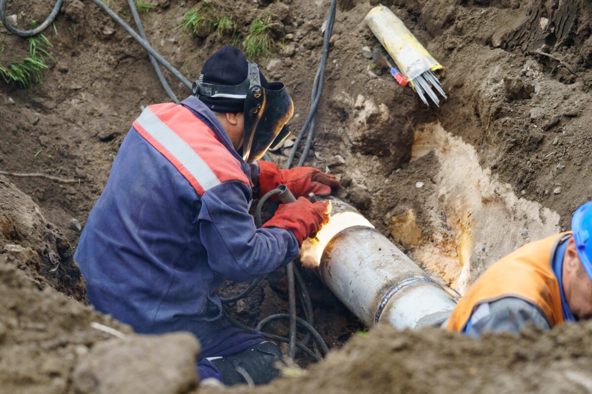 Workers welding a broken water main pipe