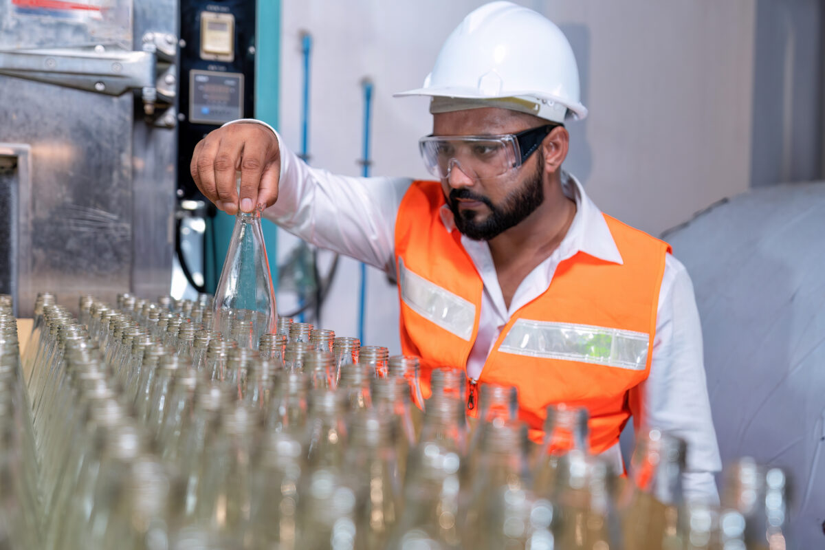 maintenance engineer monitors bottles on production line