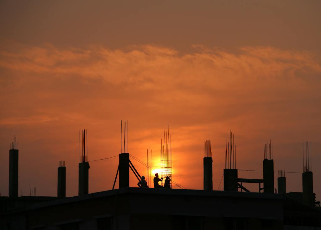Silhouette of Men in Construction Site during Sunset. Role of digital workflows in construction