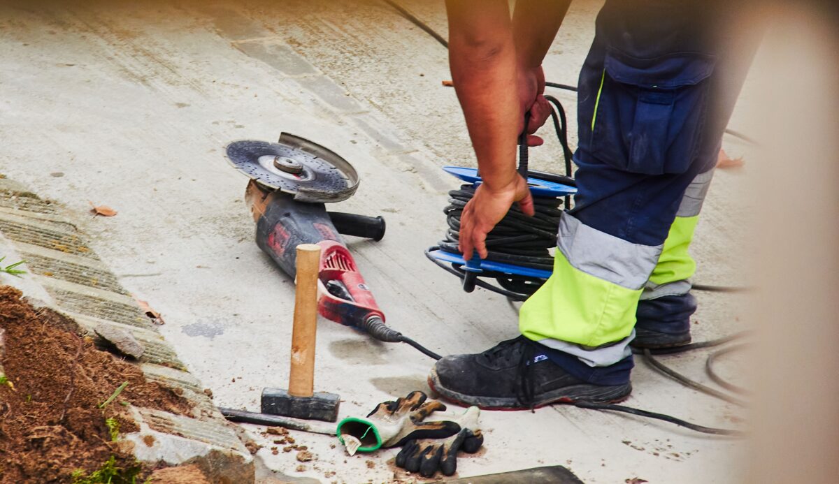 man with electric grinder, hammer and gloves