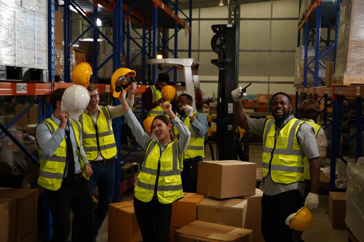 team of workers cheer inside warehouse