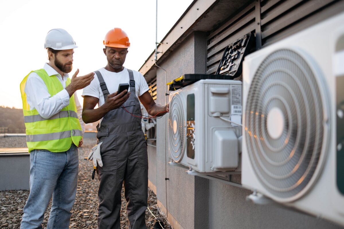 two technicians assess building cooling system on multimeter
