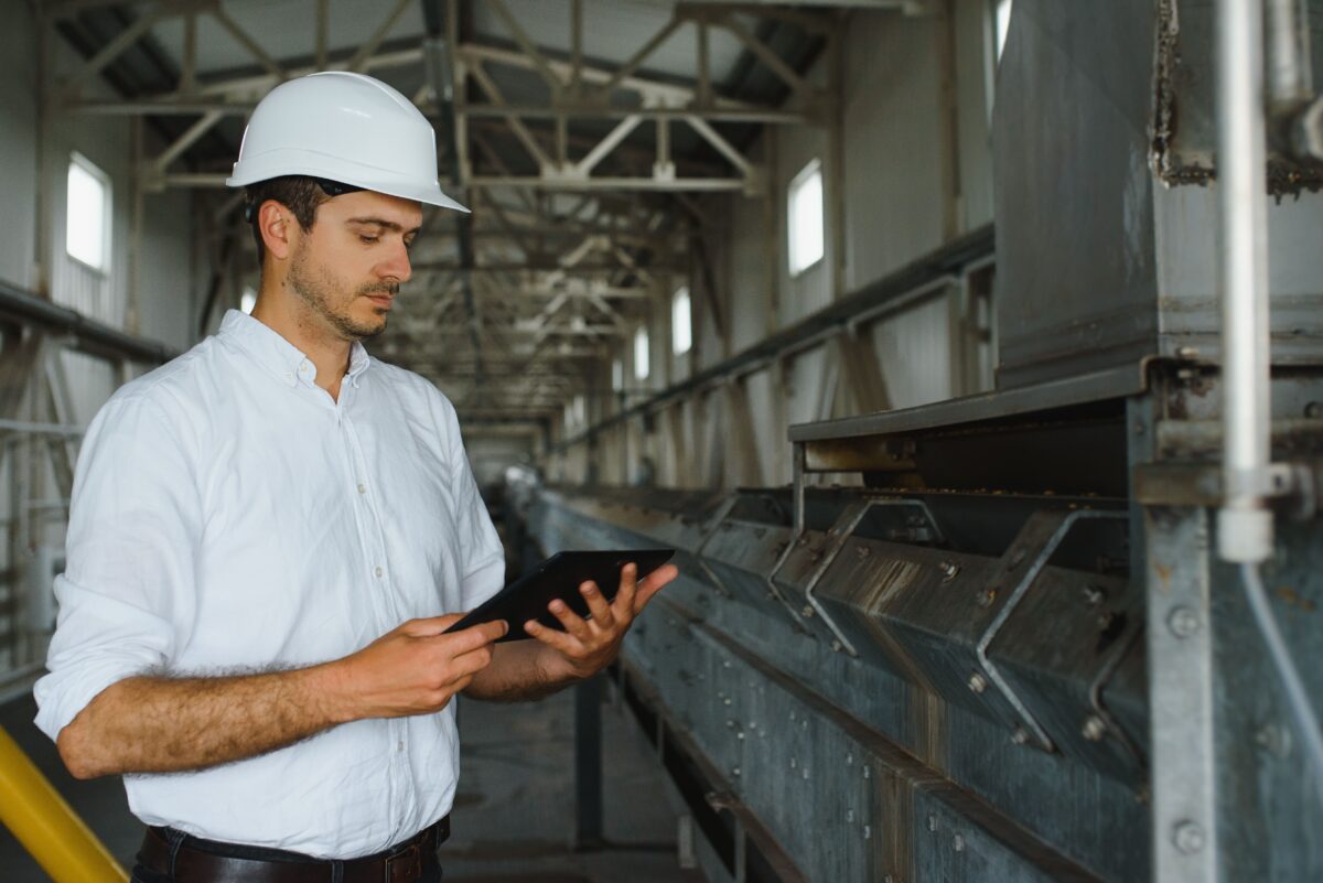 male industrial technician looks at tablet in factory