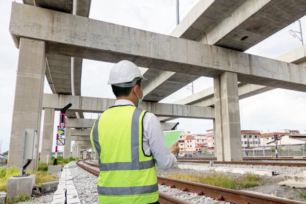 engineer with tablet inspecting under concrete road or bridge structure