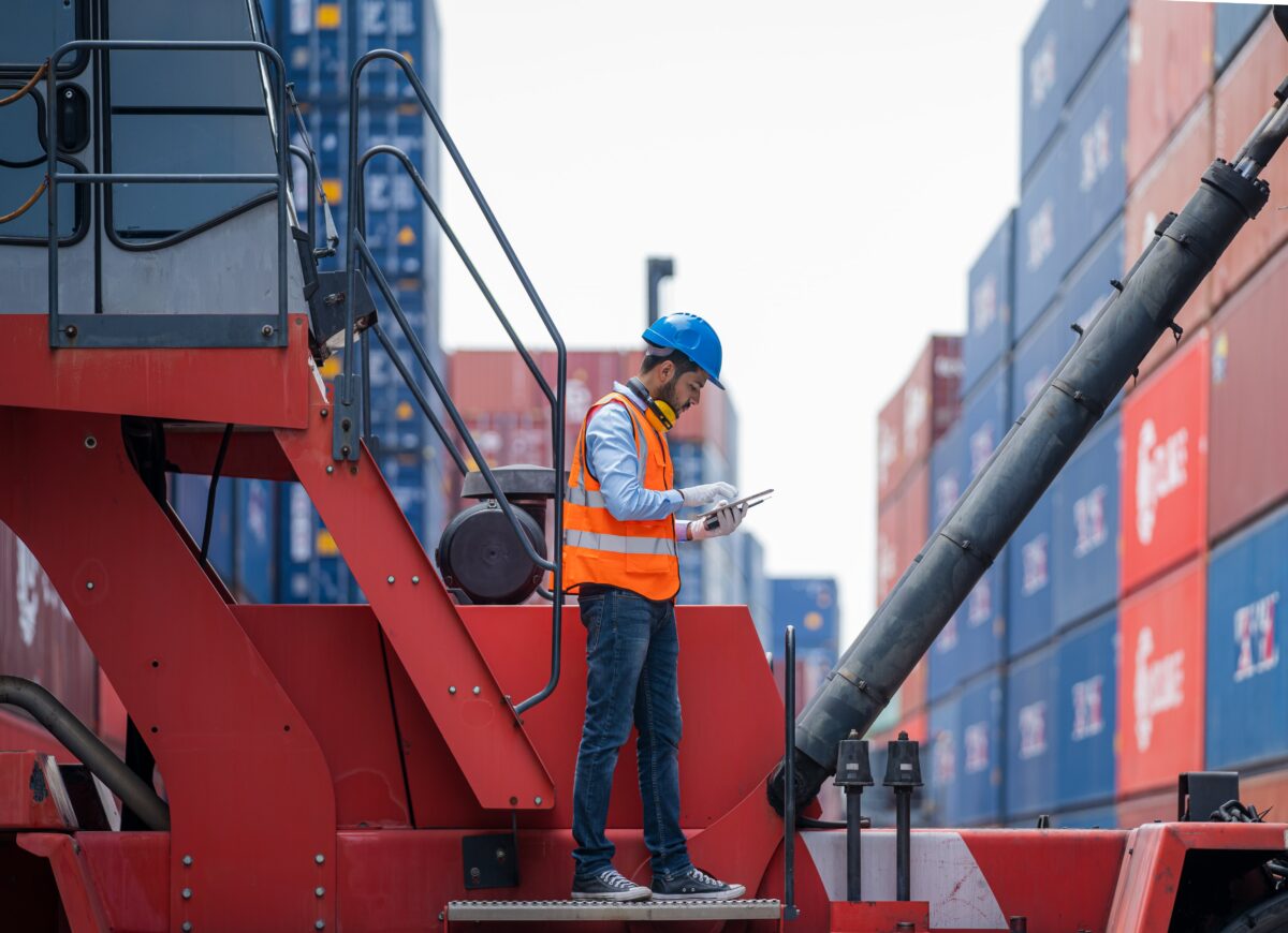 port worker checks container information on tablet