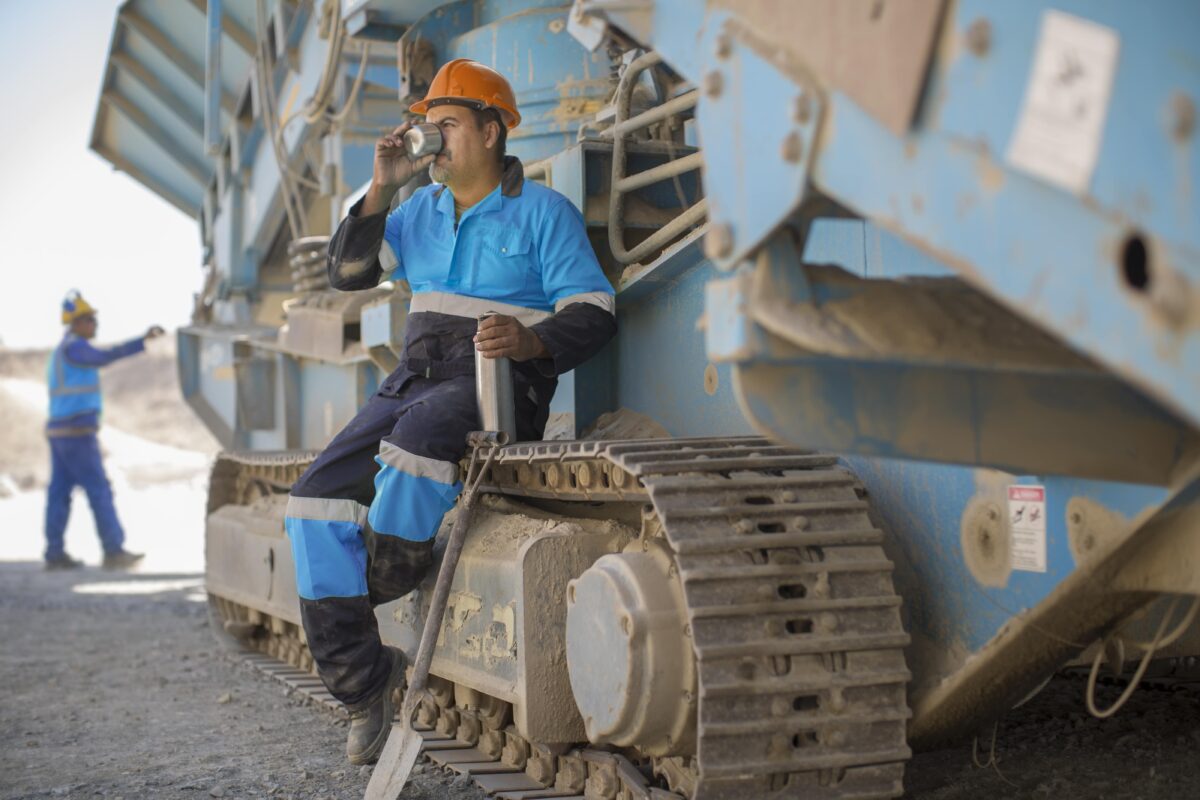 quarry worker resting on the tracks of excavator