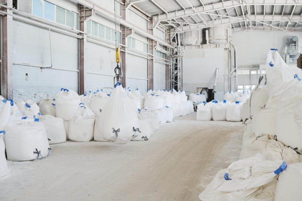 numerous half-filled white sacks on floor of industrial plant