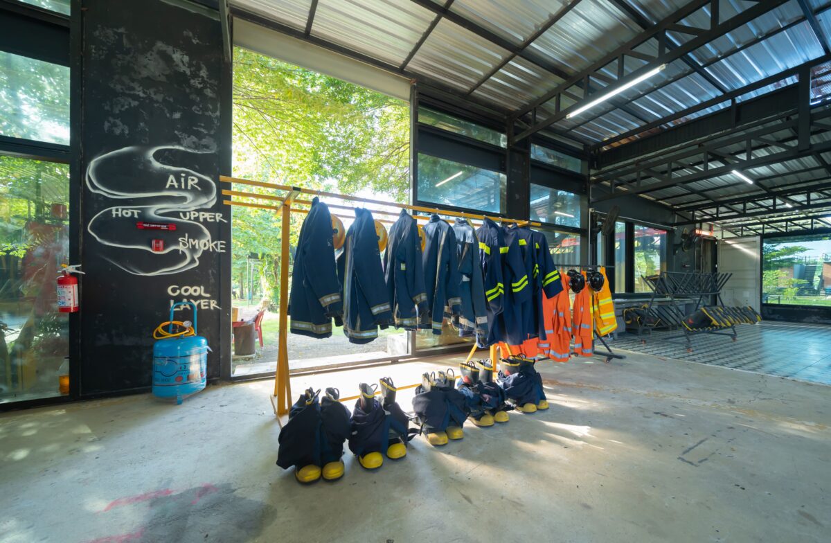 firefighter suits and boots on a rack in warehouse