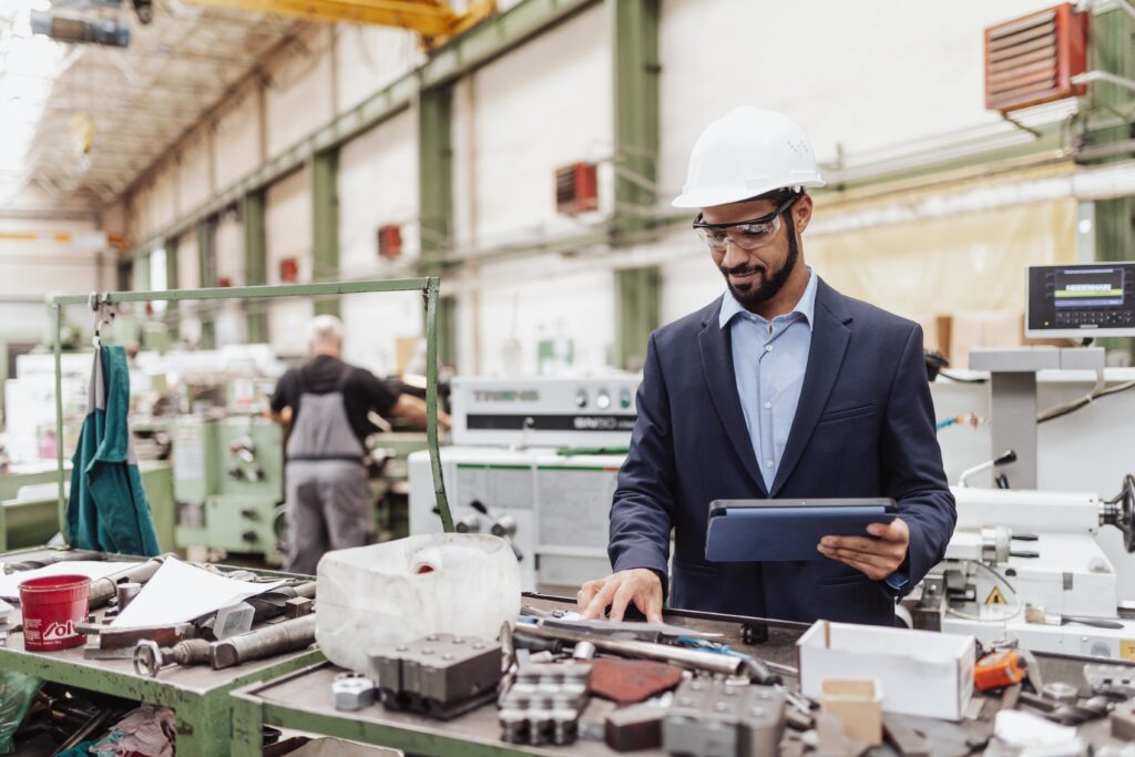 engineer manager holding tablet doing routine checkups in work area