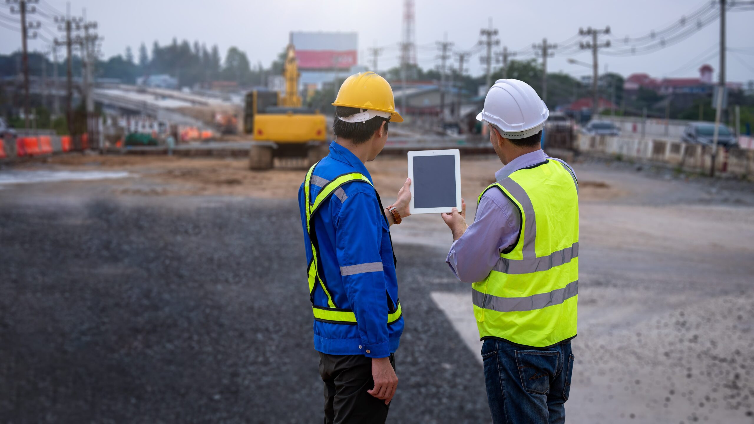 road construction engineers in safety uniform looking at tablet